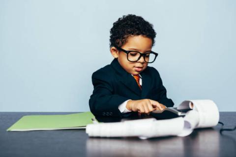 Image of young student with adding machine. 